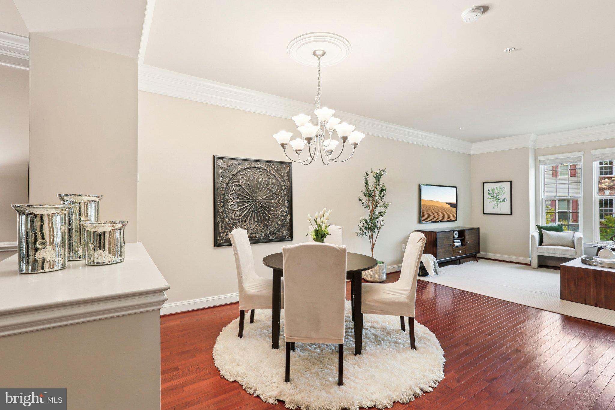 9384 Rock Ripple Lane Laurel, MD 20723 - Photo 5 of 42 a dining room with wooden floor a chandelier a glass table and chairs