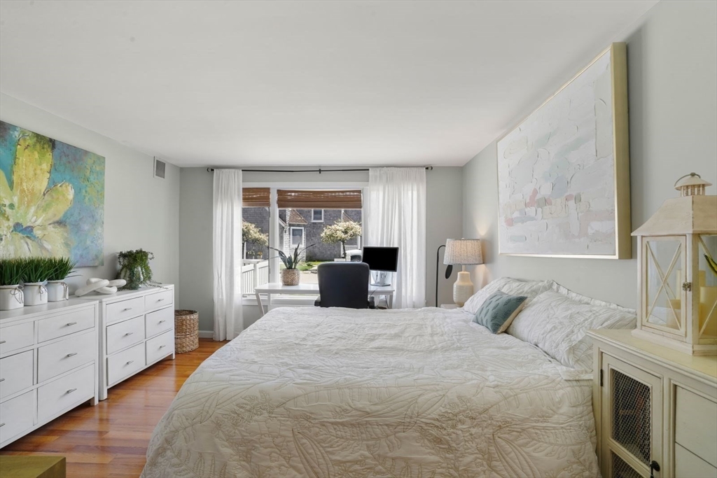 1 Commodore Court, Unit 104 Hull, MA 02045 - Photo 14 of 35 a large bedroom with a bed and a flat tv screen in it