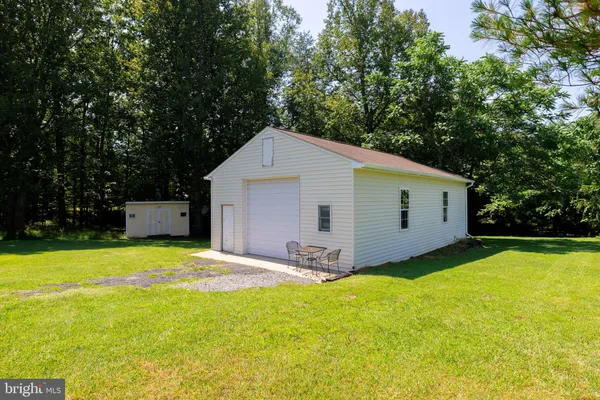 a view of a house with backyard and trees