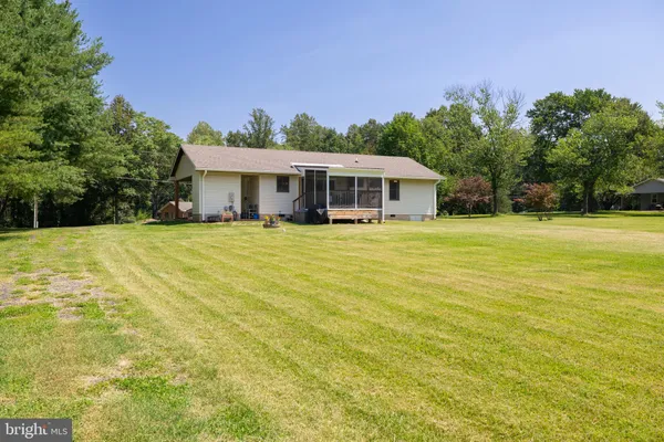a front view of house with yard and trees in the background