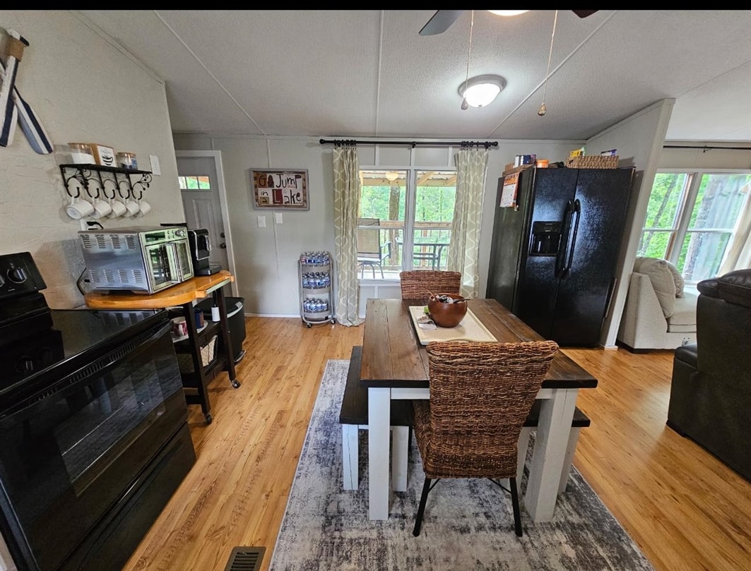 390 Wharf Road Savannah, TN 38372 - Photo 5 of 17 Dining area featuring wood-finish flooring, a ceiling fan, and sliding glass doors to the exterior