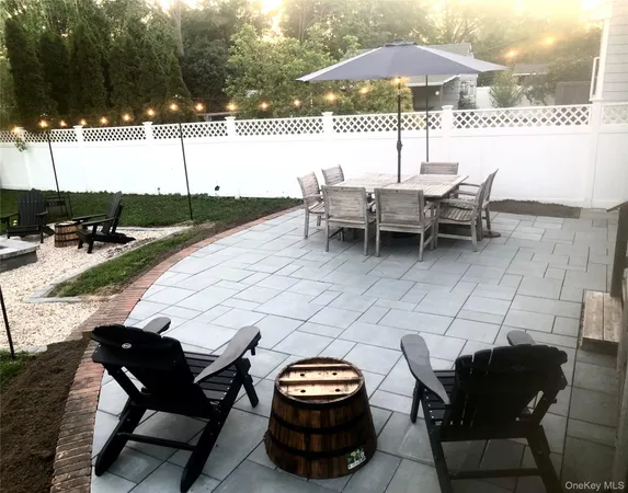 a view of a patio with a table and chairs under an umbrella