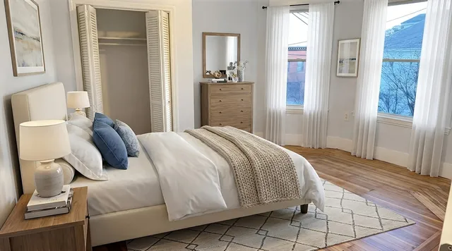 a bedroom with a bed and wooden floor