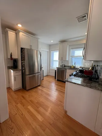 a kitchen with granite countertop a refrigerator and a stove top oven