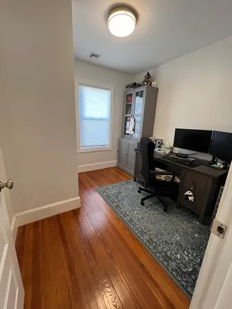 a view of a workspace with furniture and wooden floor