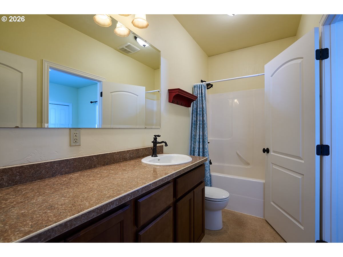 612 North Mill Street Joseph, OR 97846 - Photo 22 of 32 a bathroom with a granite countertop sink a toilet a mirror and bathtub