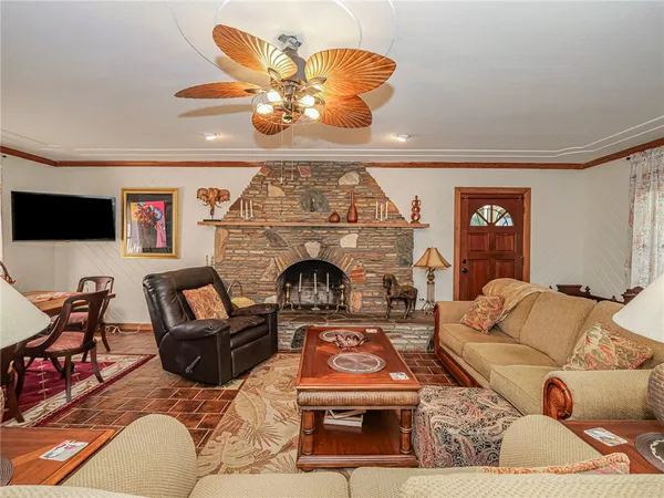 a living room with furniture a chandelier and a fireplace