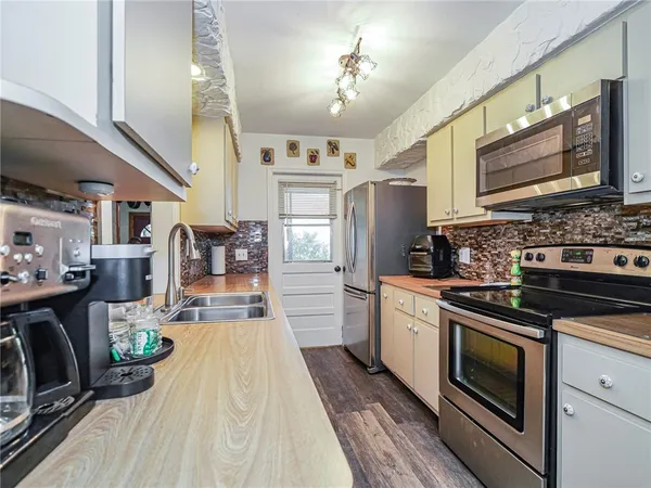 a kitchen with stainless steel appliances granite countertop a lot of counter space and wooden floors
