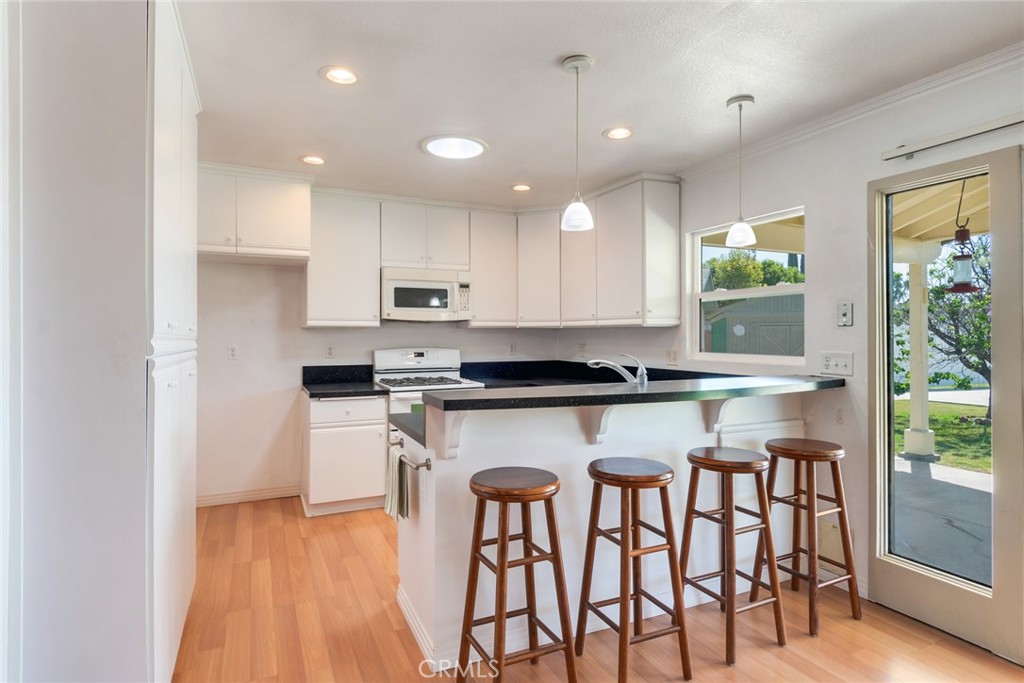 9130 Duncan Avenue Riverside, CA 92503 - Photo 11 of 34 a kitchen with a table chairs microwave and cabinets
