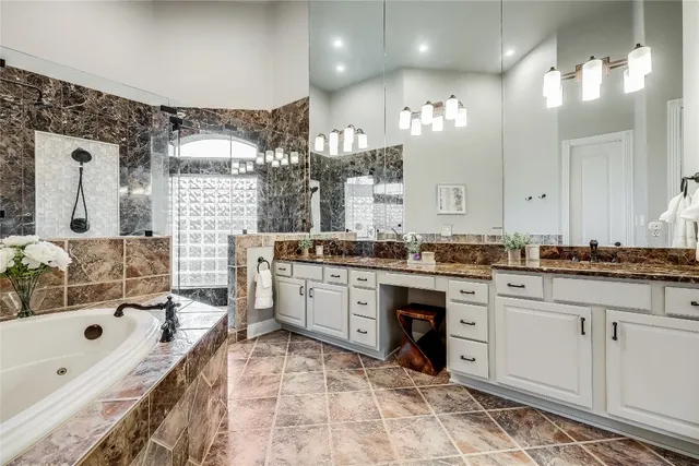a bathroom with a granite countertop sink double vanity and a bathtub