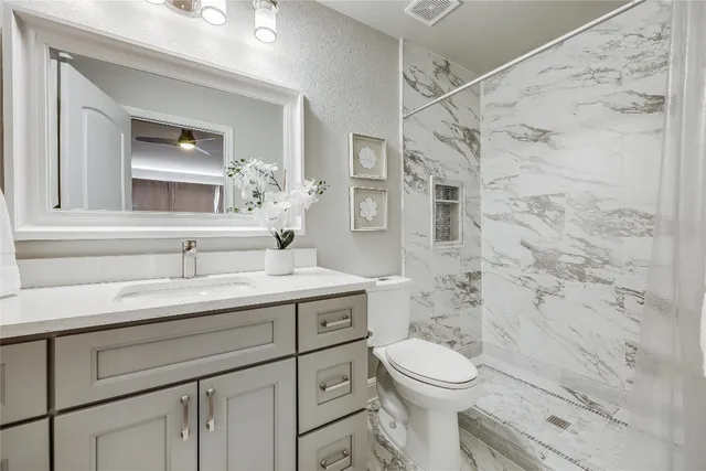 a bathroom with a sink a toilet and shower