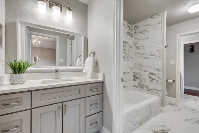 a bathroom with a bathtub sink and mirror