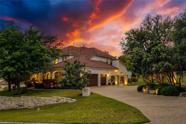 a front view of a house with a garden and a tree