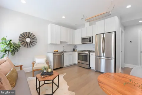 a kitchen with a refrigerator table and chairs