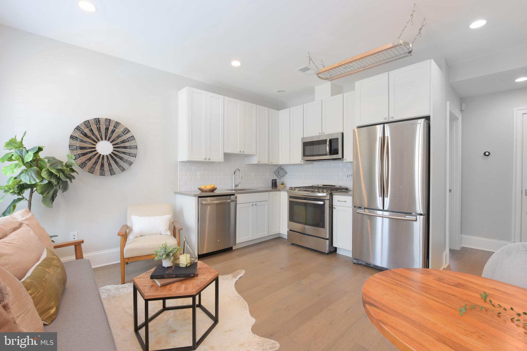 3921 Fulton Street Northwest, Unit 3 Washington, DC 20007 - Photo 11 of 24 a kitchen with a refrigerator table and chairs
