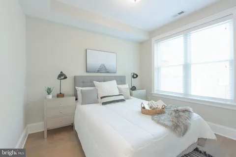 a bedroom with a bed and a large window