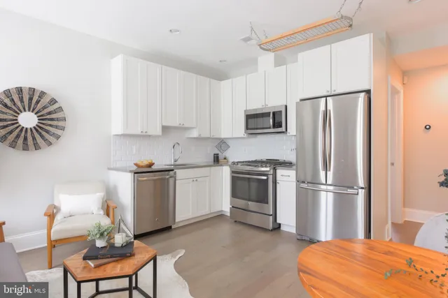 a kitchen with stainless steel appliances a refrigerator sink and white cabinets