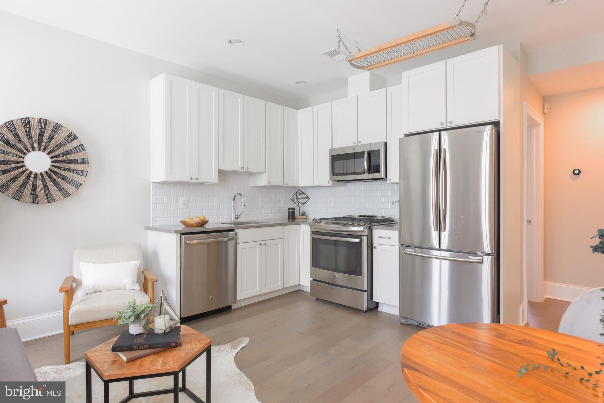 3921 Fulton Street Northwest, Unit 3 Washington, DC 20007 - Photo 6 of 24 a kitchen with stainless steel appliances a refrigerator sink and white cabinets