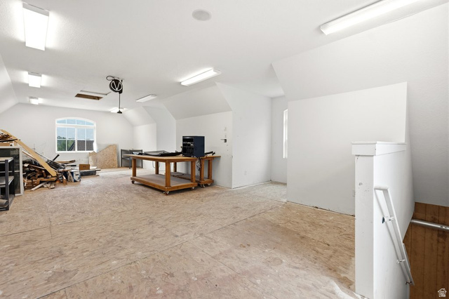 672 Perry Hollow Drive Mapleton, UT 84664 - Photo 87 of 106 Spacious attic with vaulted ceilings, plywood subflooring, arched window, abundant overhead lighting, and white painted walls