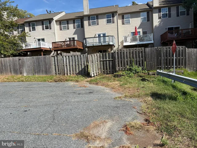 a view of a house with a small yard and wooden fence