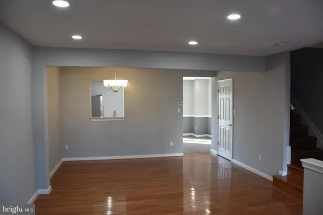 a view of empty room with wooden floor