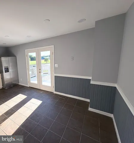 a view of an empty room with window and bathroom