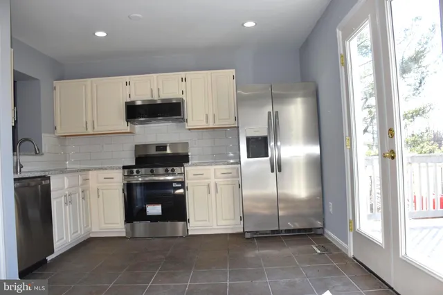 a kitchen with stainless steel appliances a refrigerator sink and microwave