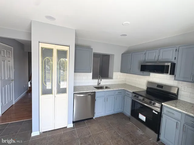 a kitchen with stainless steel appliances granite countertop a sink and cabinets