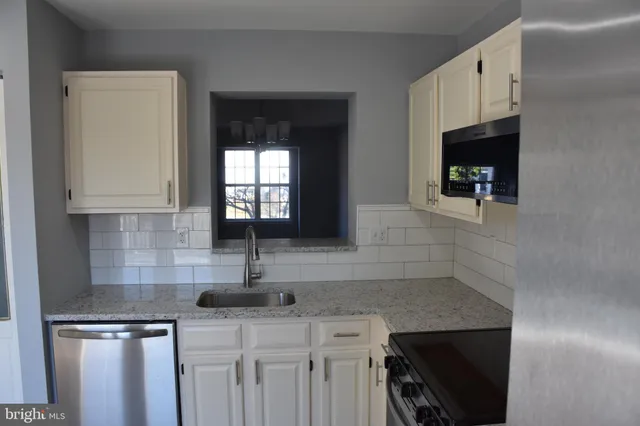 a kitchen with stainless steel appliances granite countertop a sink and a cabinets