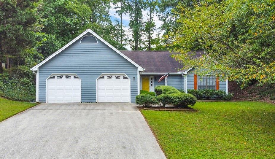 3891 Nowlin Road Kennesaw, GA 30144 - Photo 1 of 1 a front view of a house with a garden and plants