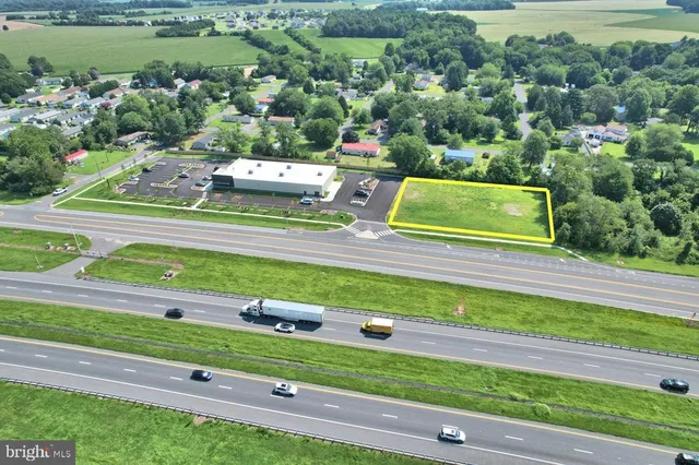 a green field with lots of trees in the background