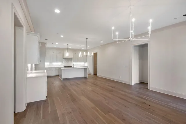 a large kitchen with a wooden floor and a window