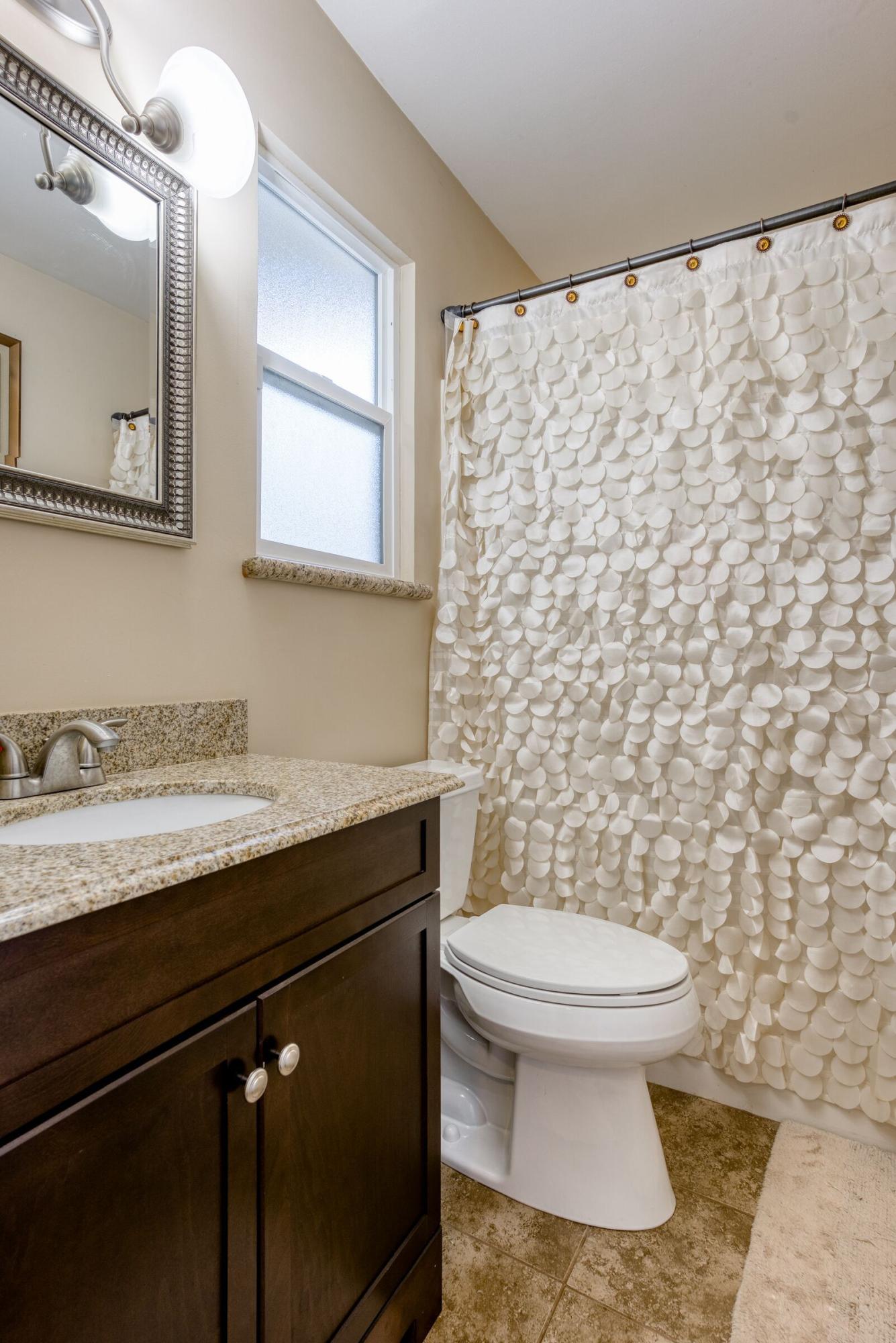 1209 Woodside Meadows Road Redding, CA 96002 - Photo 12 of 22 a bathroom with a granite countertop sink a toilet and a mirror