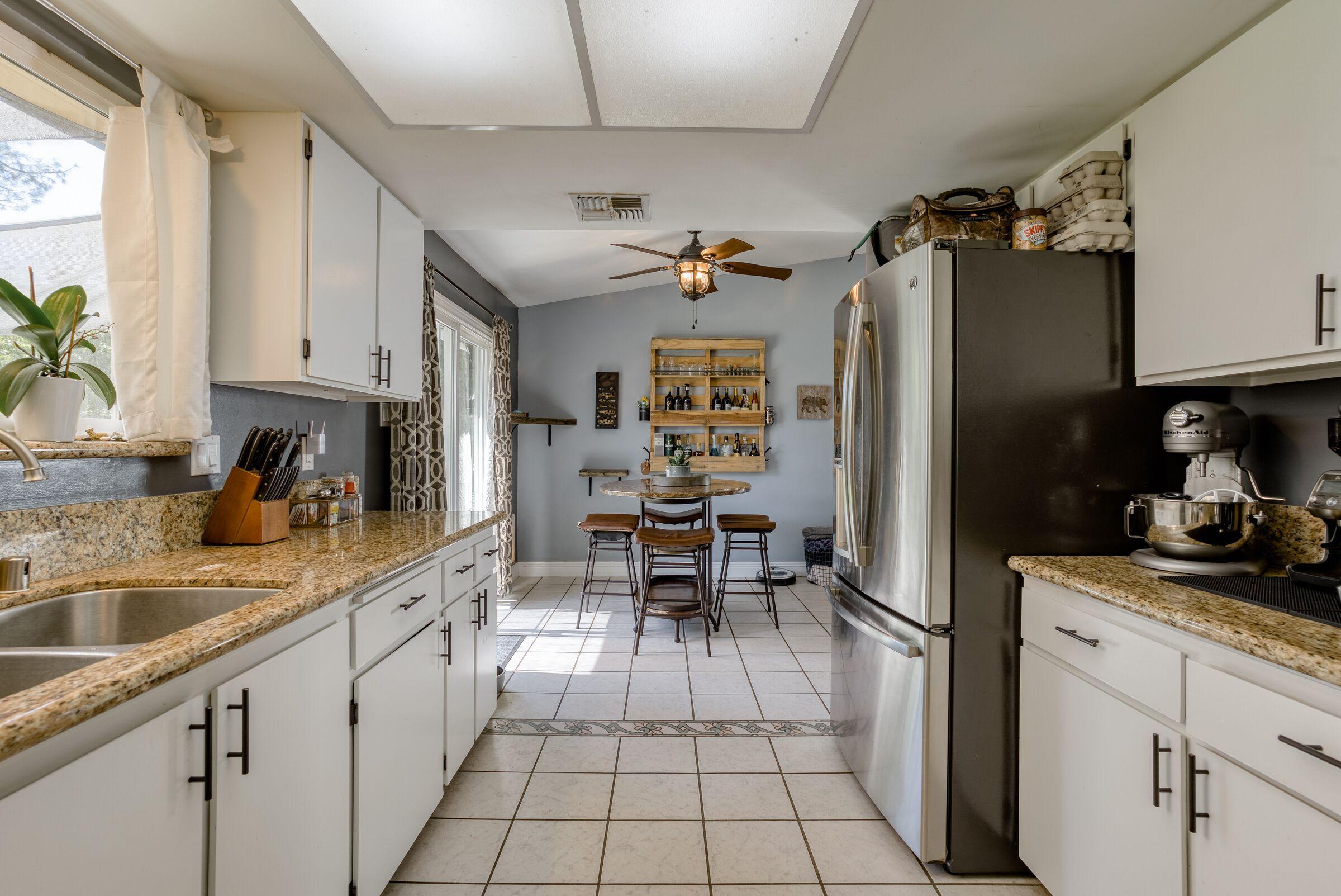 1209 Woodside Meadows Road Redding, CA 96002 - Photo 9 of 22 a kitchen with granite countertop a sink appliances cabinets and furniture