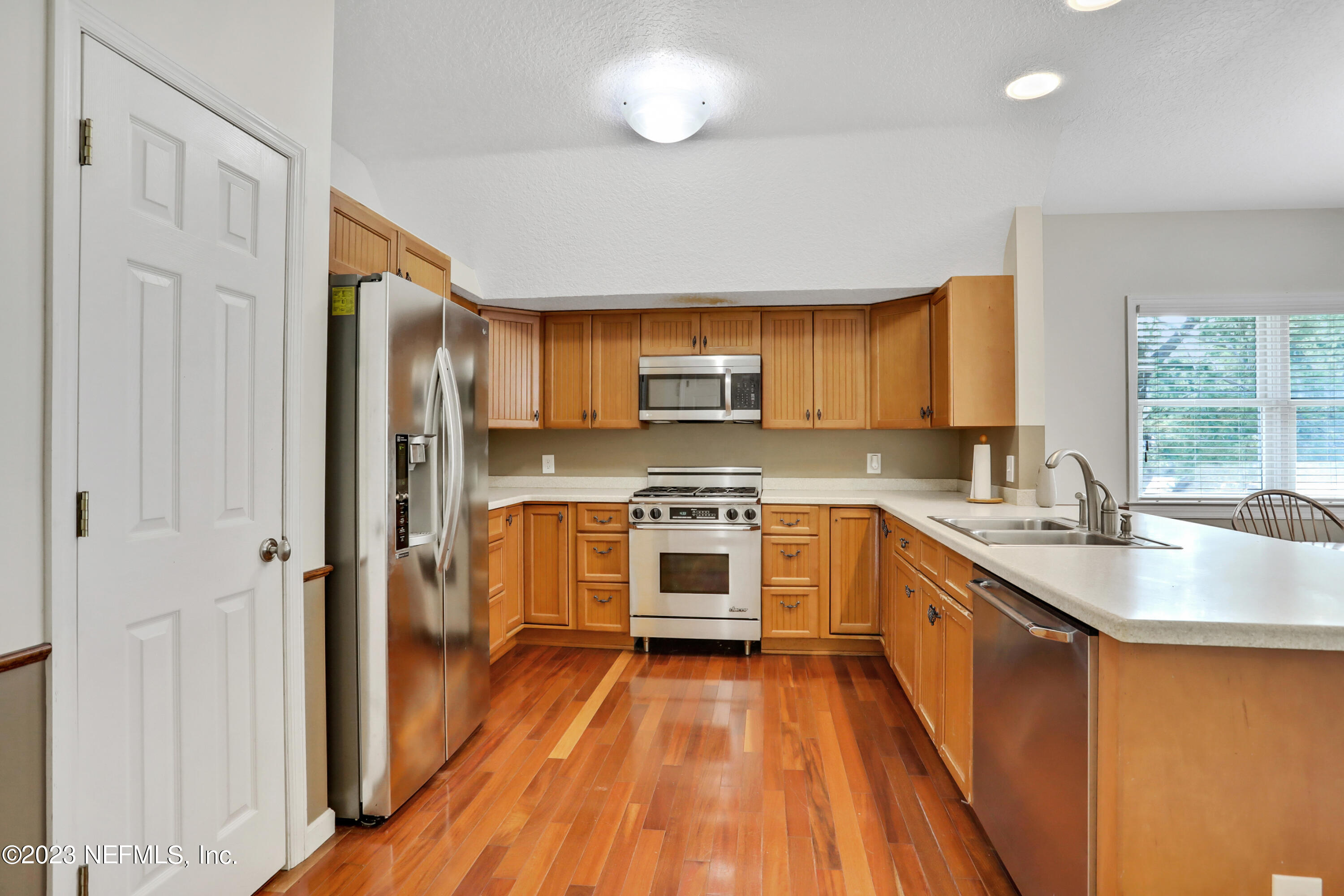 10100 Heckscher Drive Jacksonville, FL 32226 - Photo 34 of 90 a kitchen with stainless steel appliances a stove a sink dishwasher a refrigerator and a microwave oven with wooden floor