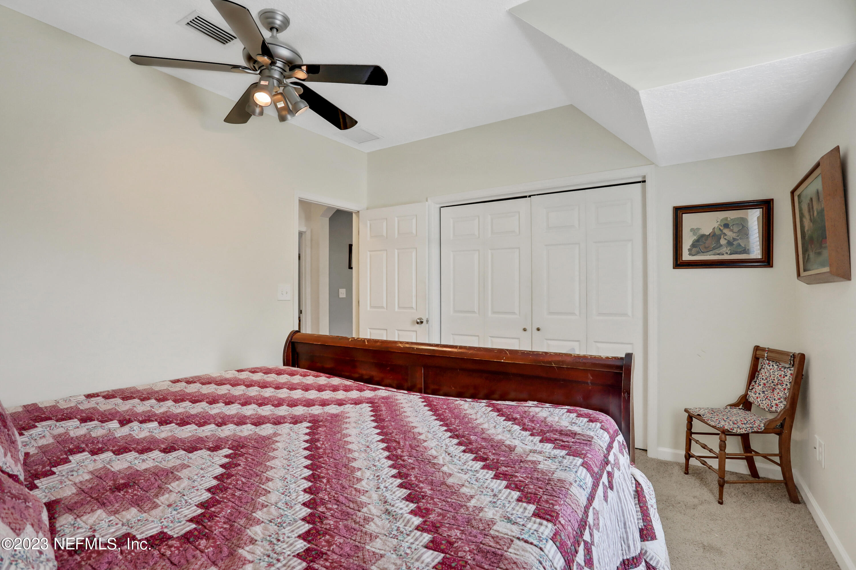 10100 Heckscher Drive Jacksonville, FL 32226 - Photo 46 of 90 a bedroom with a large bed and a chandelier