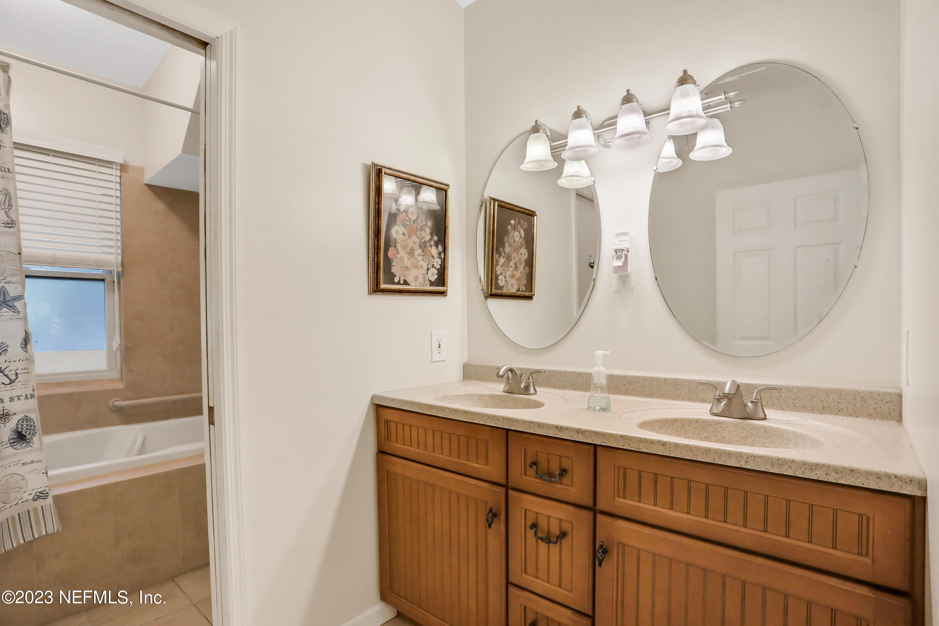 10100 Heckscher Drive Jacksonville, FL 32226 - Photo 52 of 90 a bathroom with a double vanity sink mirror and chandelier