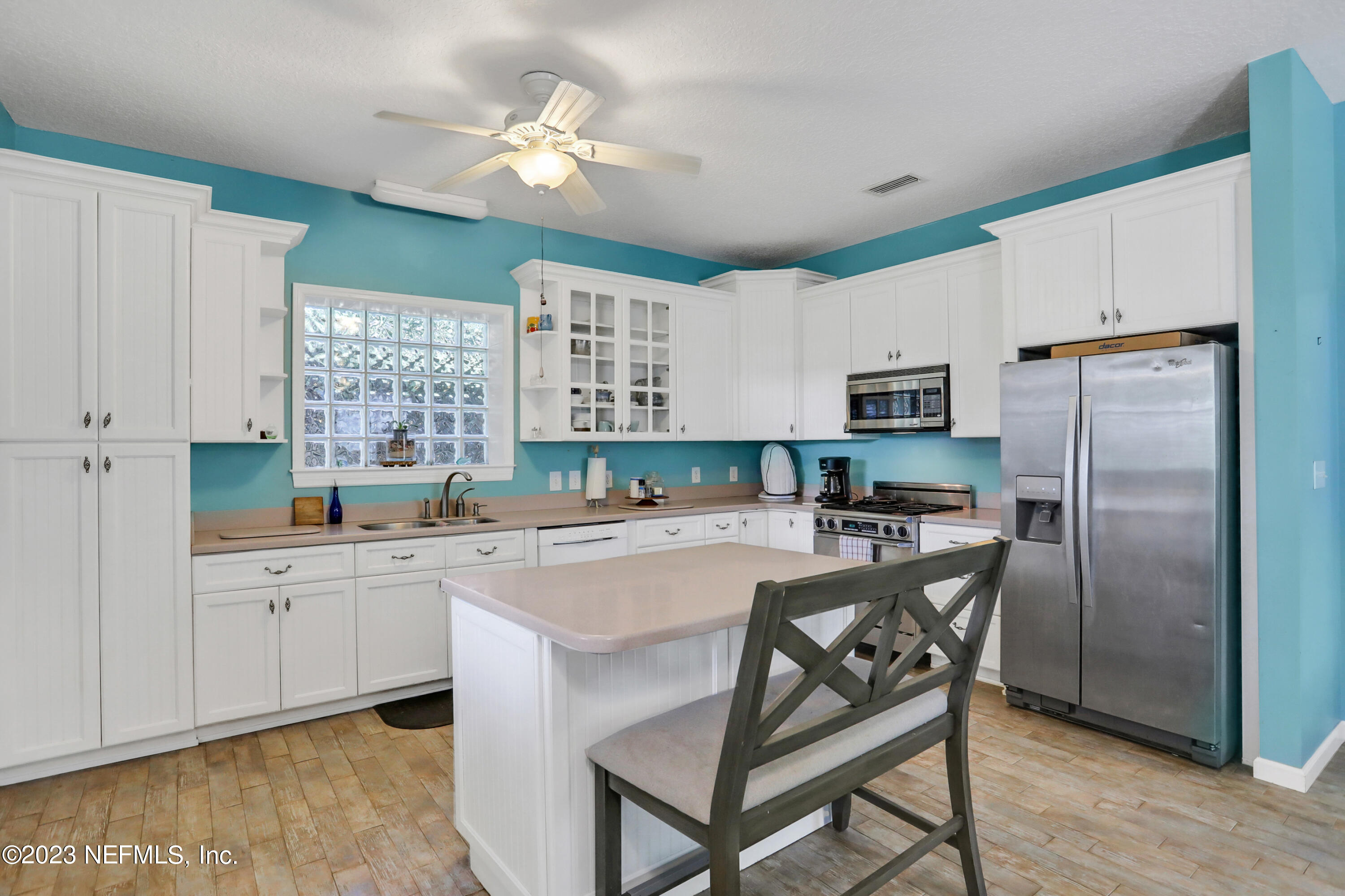 10100 Heckscher Drive Jacksonville, FL 32226 - Photo 57 of 90 a kitchen with stainless steel appliances a stove a sink dishwasher a refrigerator with white cabinets and wooden floor