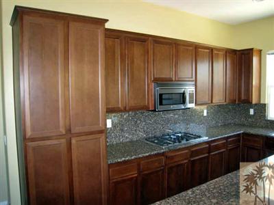 81908 Villa Reale Drive Indio, CA 92203 - Photo 5 of 25 a kitchen with granite countertop wooden cabinets