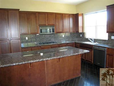 81908 Villa Reale Drive Indio, CA 92203 - Photo 8 of 25 a kitchen with kitchen island granite countertop a sink a counter top space and cabinets