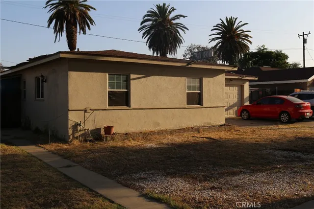 a front view of house with yard and car parked