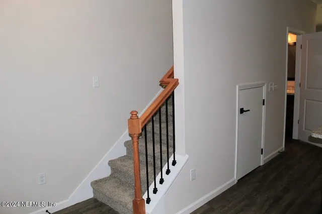 a view of staircase with wooden floor and white walls