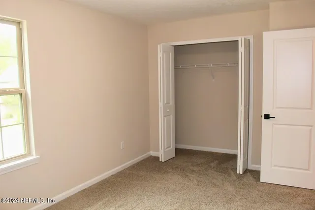 an empty room with windows and closet