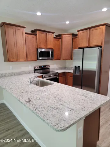 a kitchen with stainless steel appliances granite countertop a sink refrigerator and microwave