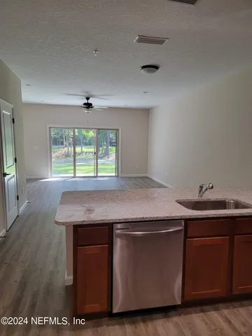 a room with kitchen island a sink and wooden floor