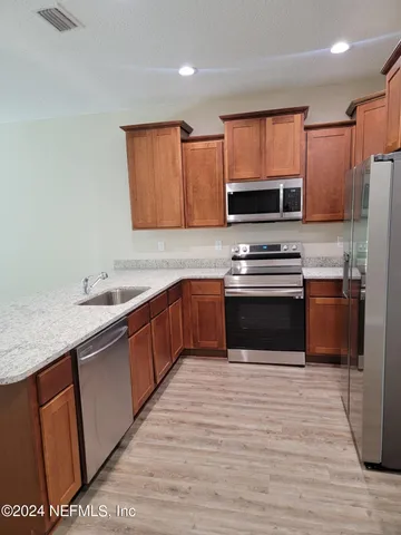 a kitchen with stainless steel appliances granite countertop a stove microwave and sink