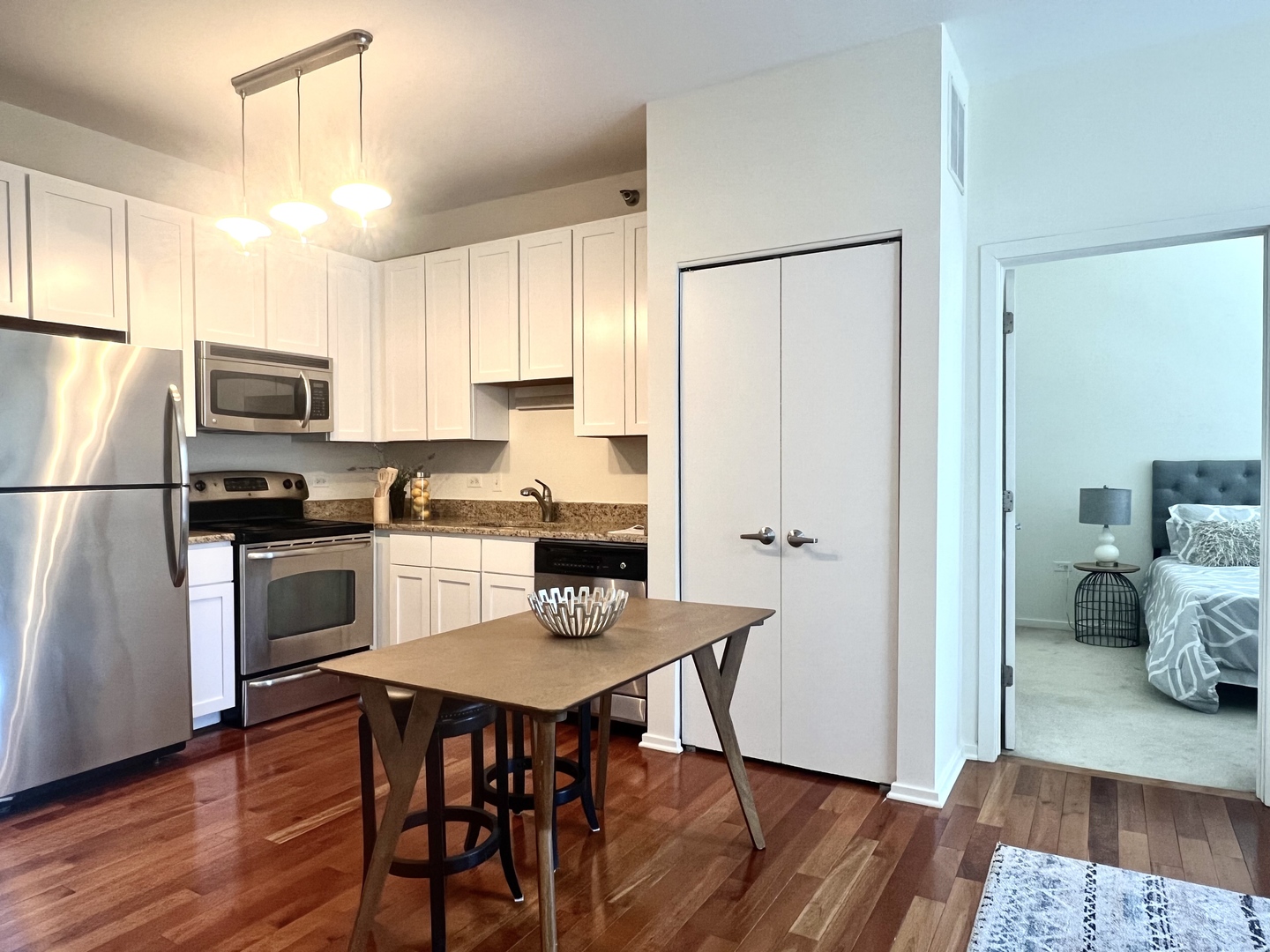 1 East 8th Street, Unit 307 Chicago, IL 60605 - Photo 18 of 24 a kitchen with stainless steel appliances a refrigerator a stove a sink dishwasher and white cabinets with wooden floor