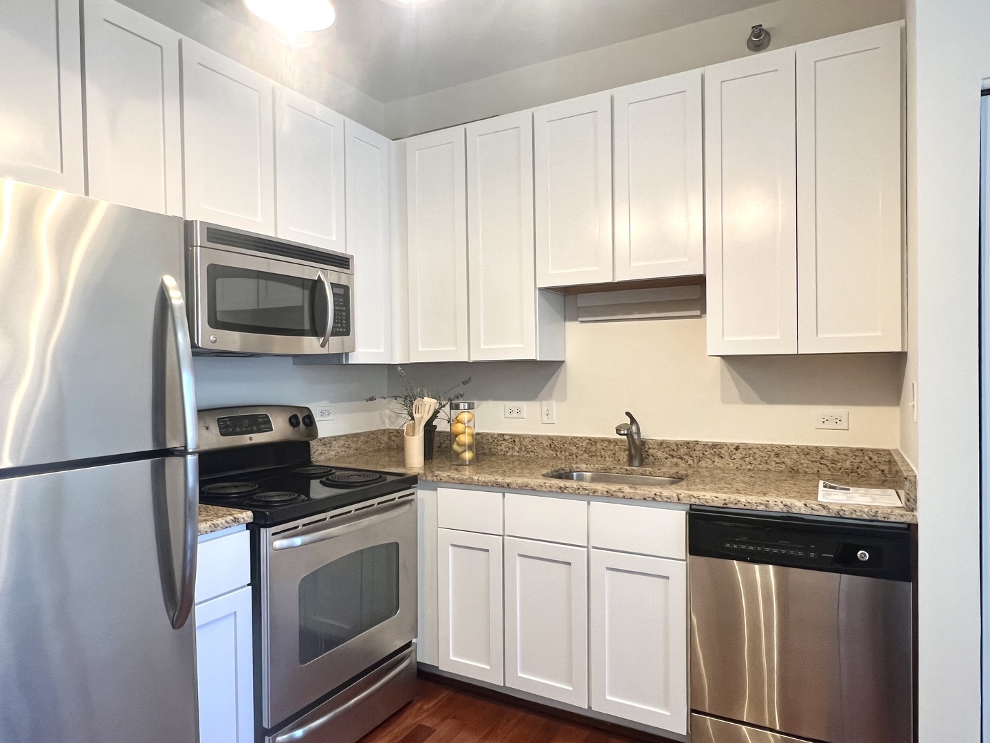 1 East 8th Street, Unit 307 Chicago, IL 60605 - Photo 19 of 24 a kitchen with granite countertop white cabinets and stainless steel appliances