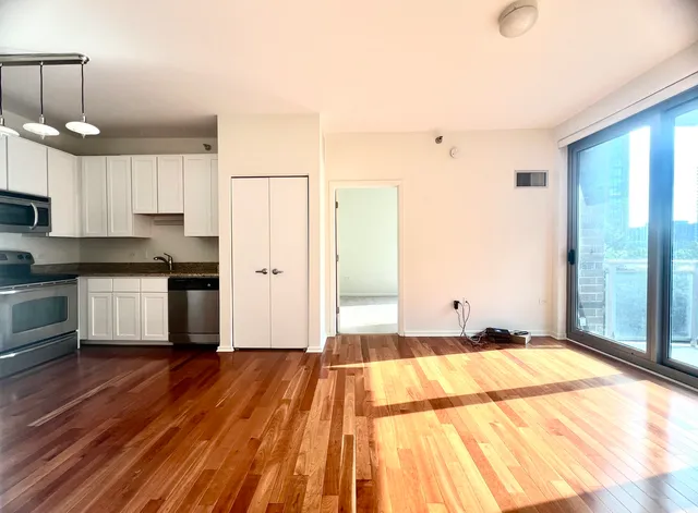 a view of a kitchen with a sink and dishwasher with wooden floor