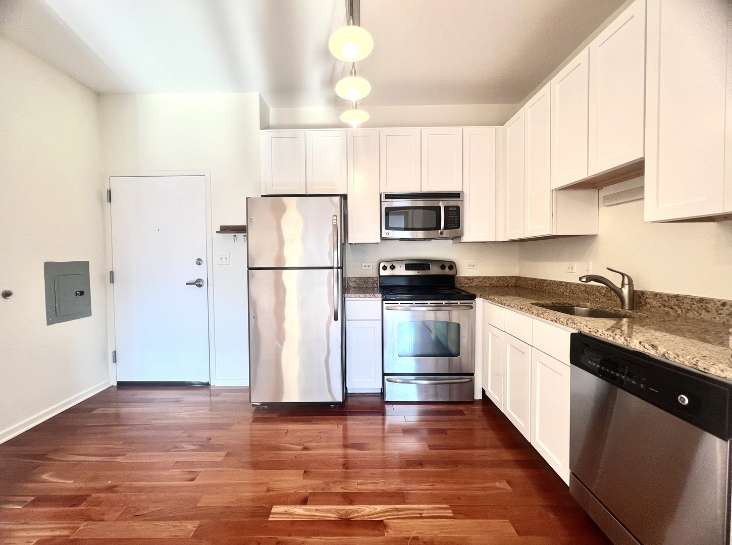 1 East 8th Street, Unit 307 Chicago, IL 60605 - Photo 5 of 23 a kitchen with kitchen island granite countertop a refrigerator stove top oven and sink